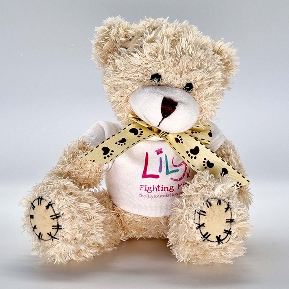 A beige teddy bear with a bow and a white t-shirt featuring the Lily Foundation logo and the words fighting mito.