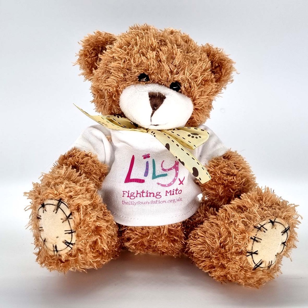 A brown teddy bear with a bow and a white t-shirt featuring the Lily Foundation logo and the words fighting mito.