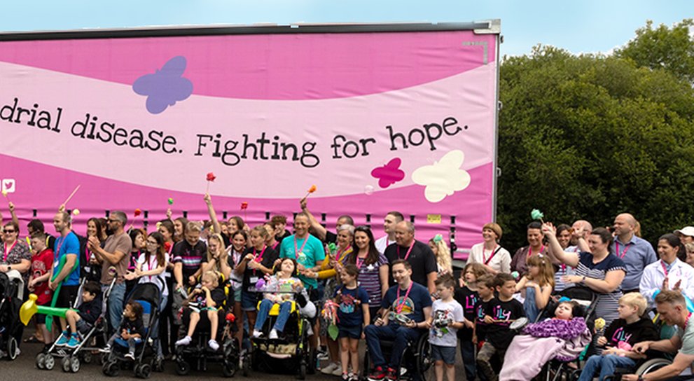 Lots of Lily families, standing in front of a huge lily branded lorry with bright pink sides and butterflies