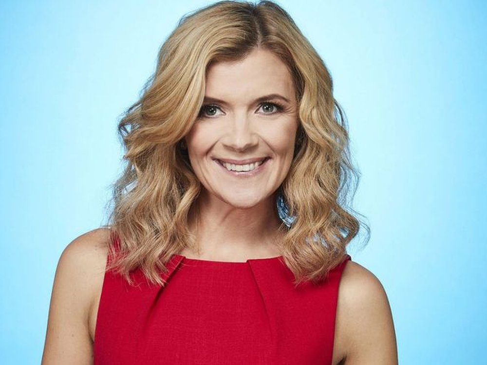 Coronation Street actor Jane Danson wearing a red sleeveless top and smiling against a blue background