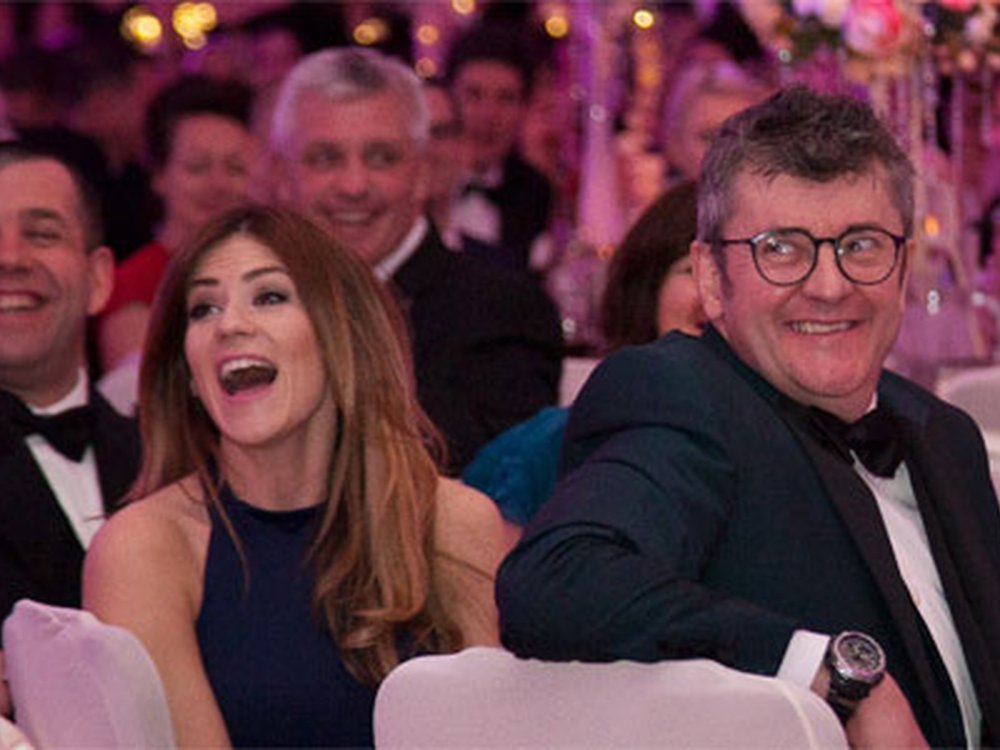 Comedian Joe Pasquale and other guests sitting at tables and laughing at the Lily Foundation charity ball