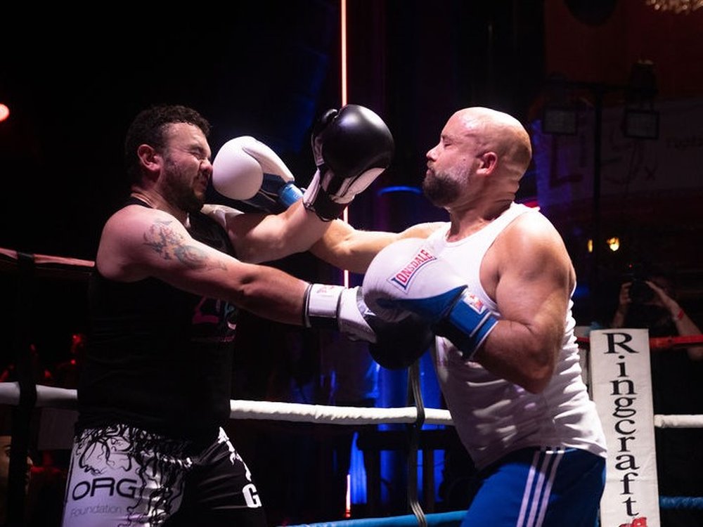 Two men i Lily vests throwing punches at each other in the ring at the Lily Foundation Fight Night