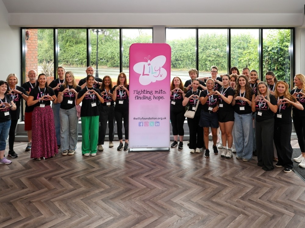 A group of volunteers in Lily Foundation tops standing either side of a banner