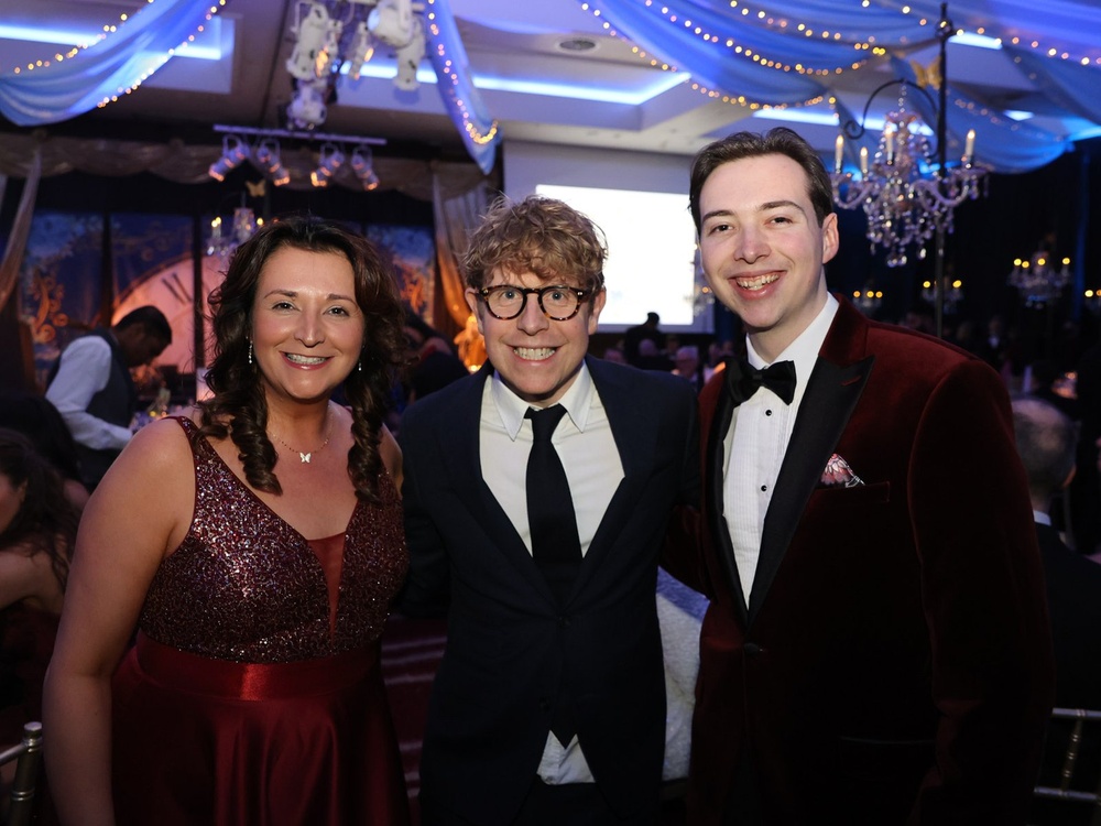 Comic Josh Widdicombe standing with two adult mito patients
