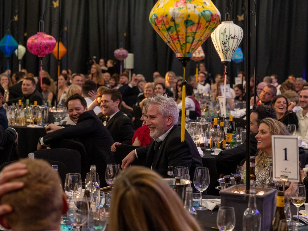 Lots of people sitting around tables at the Lily ball