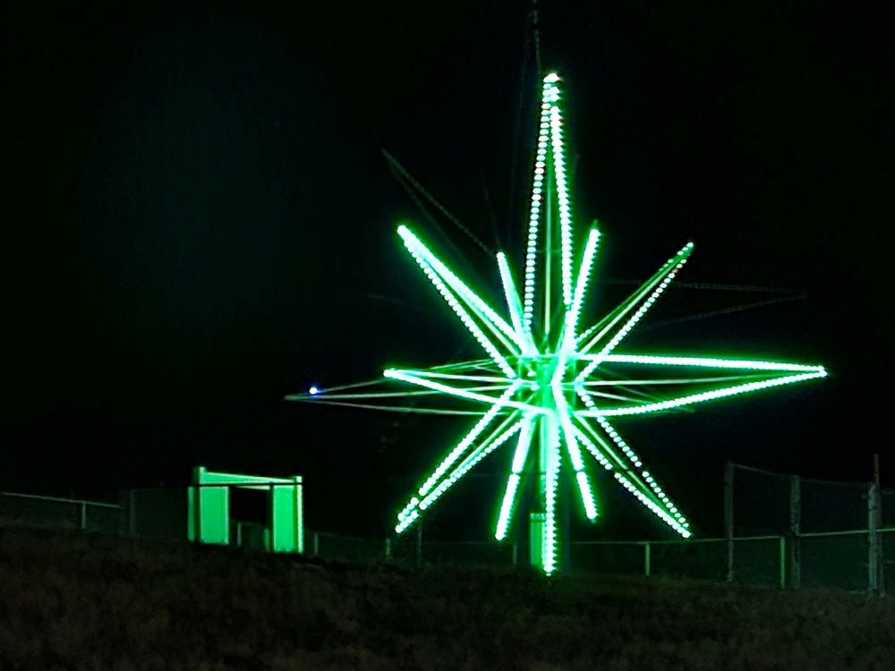 A landmark lit up green at night for World Mitochondrial Disease Week
