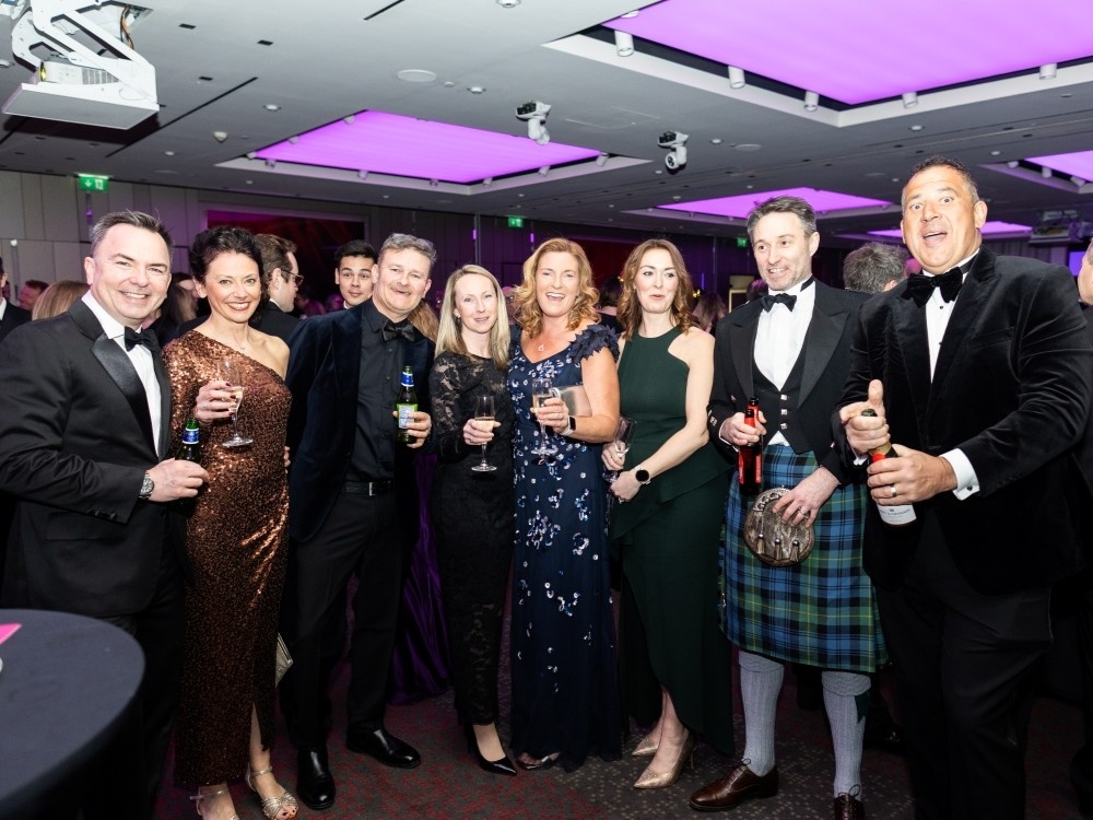 A group of people standing together saying cheers with drinks at the Lily ball