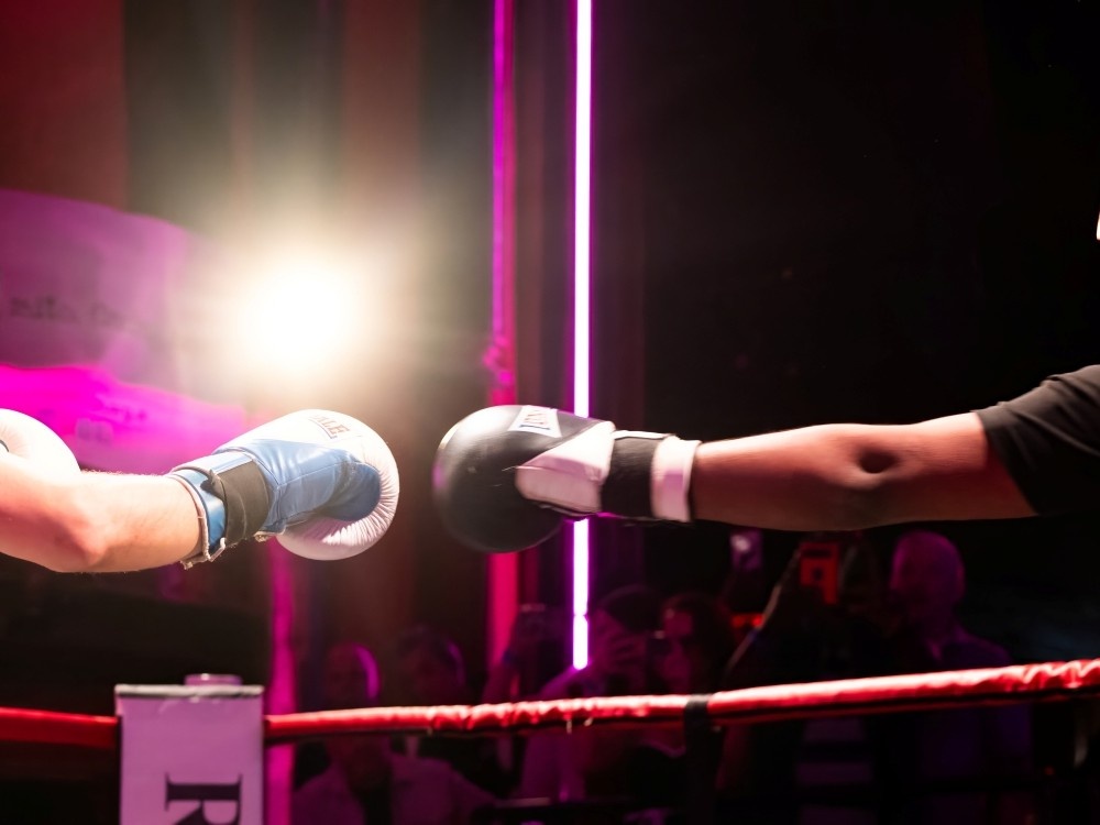 Close-up of two boxing gloves punching in the ring