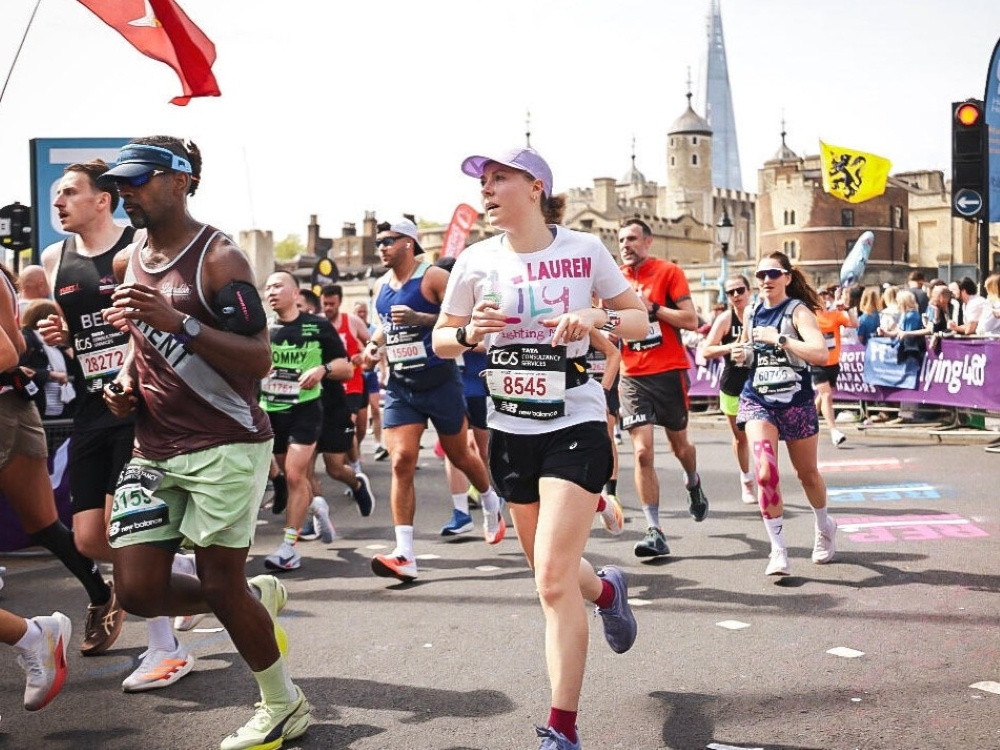 A lady running the London marathon in a Lily Foundation top