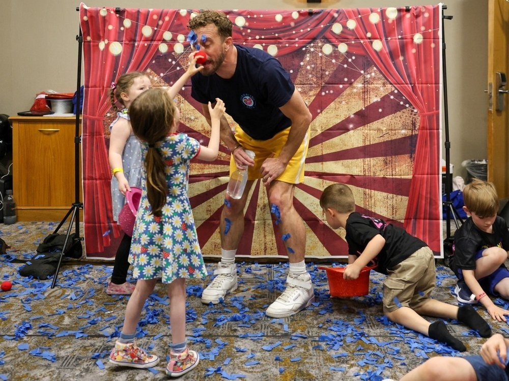 Two children having fun with a magician at the Lily support weekend