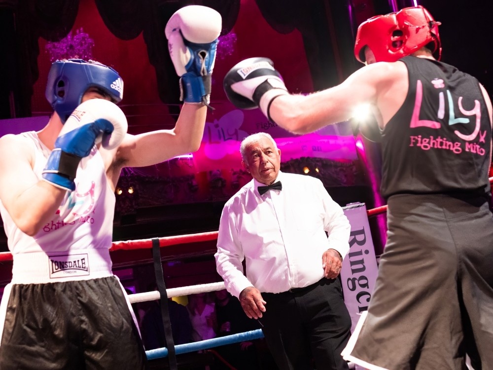 Ref Kenny Curtis watches two boxers in the ring