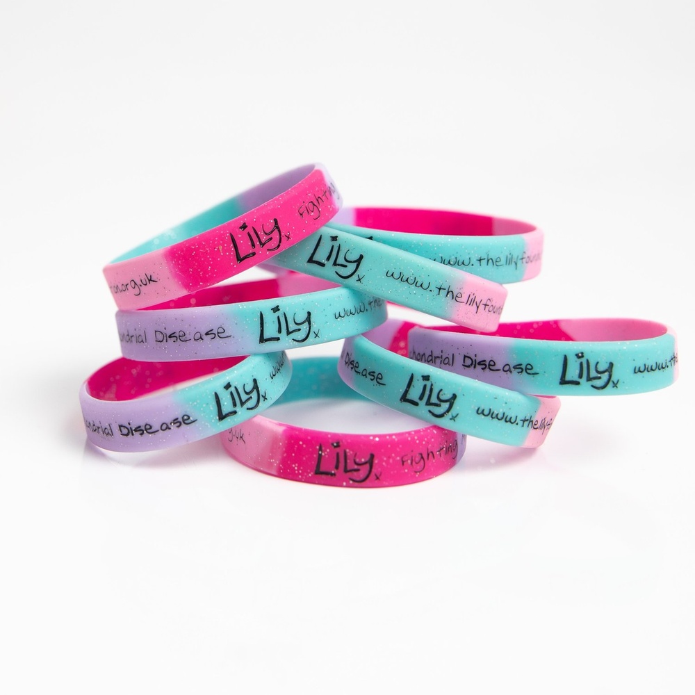 A pile of multicoloured glittery wristbands featuring the Lily Foundation logo and website address.