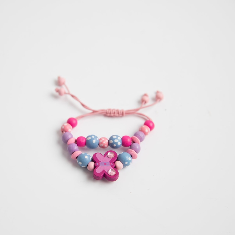 A bracelet made with wooden beads in multiple colours, a butterfly shaped bead in the center.