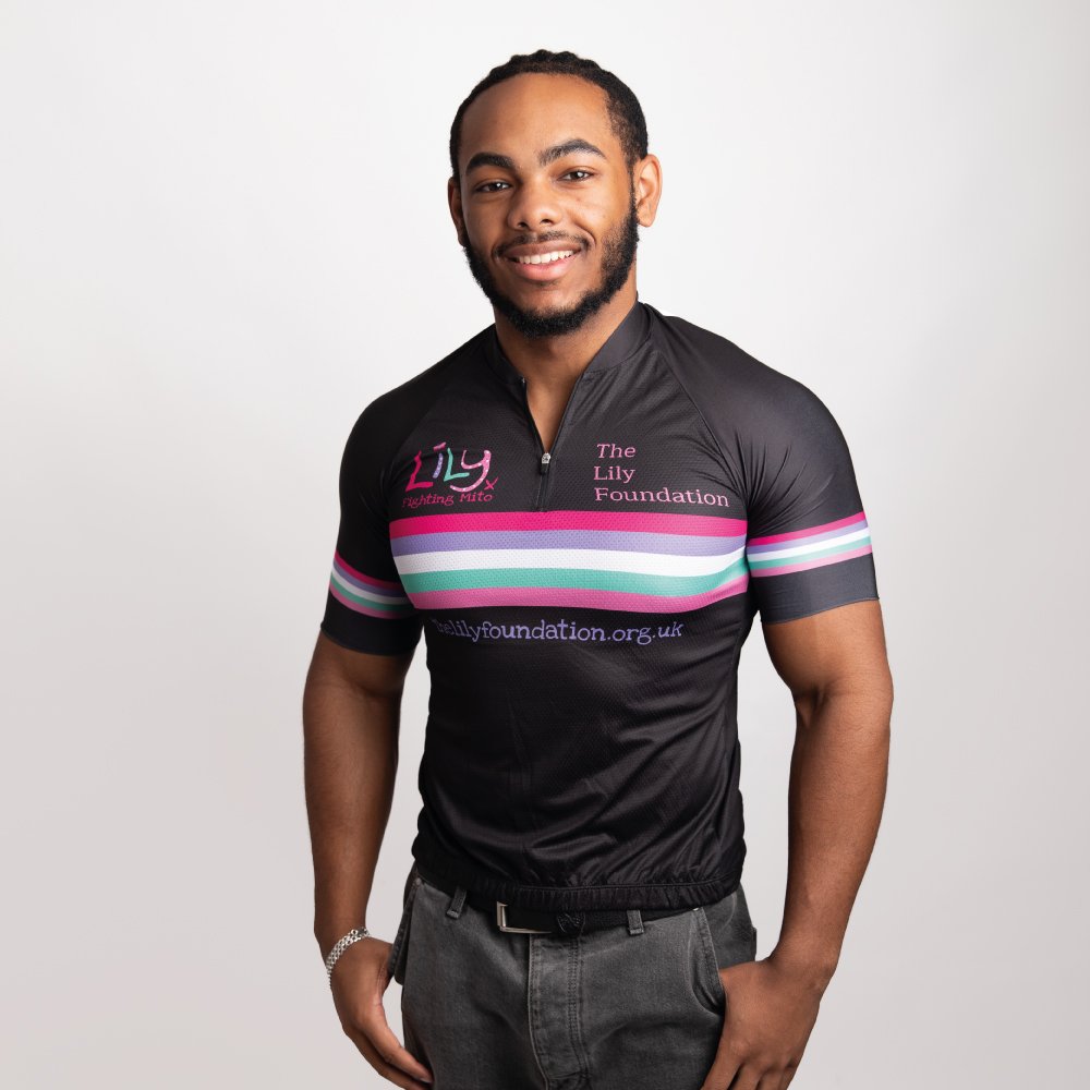 A smiling man in a black cycling top with coloured stripes across the front, the Lily Foundation logo and website address.