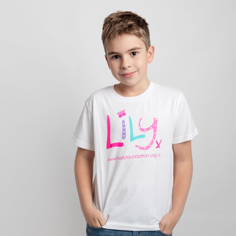 A young boy wearing a white t-shirt featuring the Lily Foundation logo and the website address.