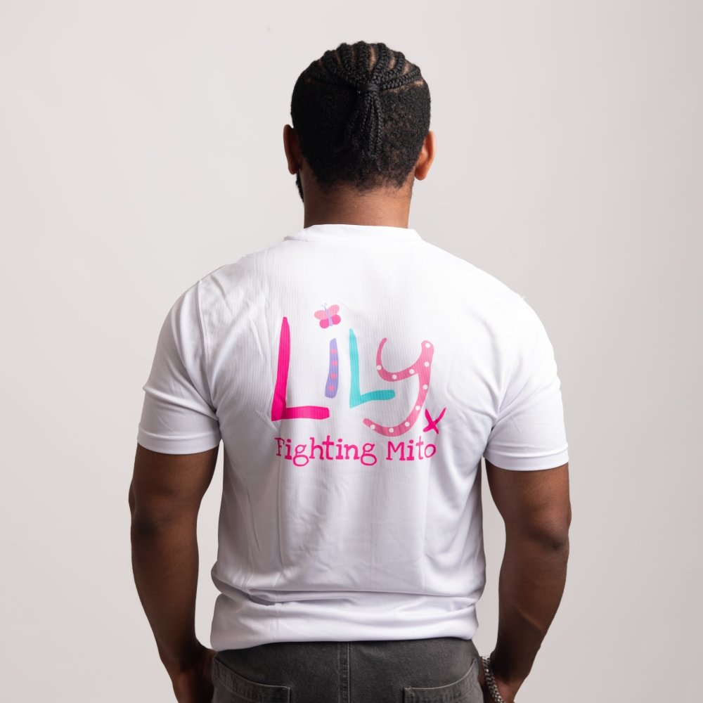 The back of a man wearing a white performance top featuring the Lily Foundation logo with fighting mito underneath.