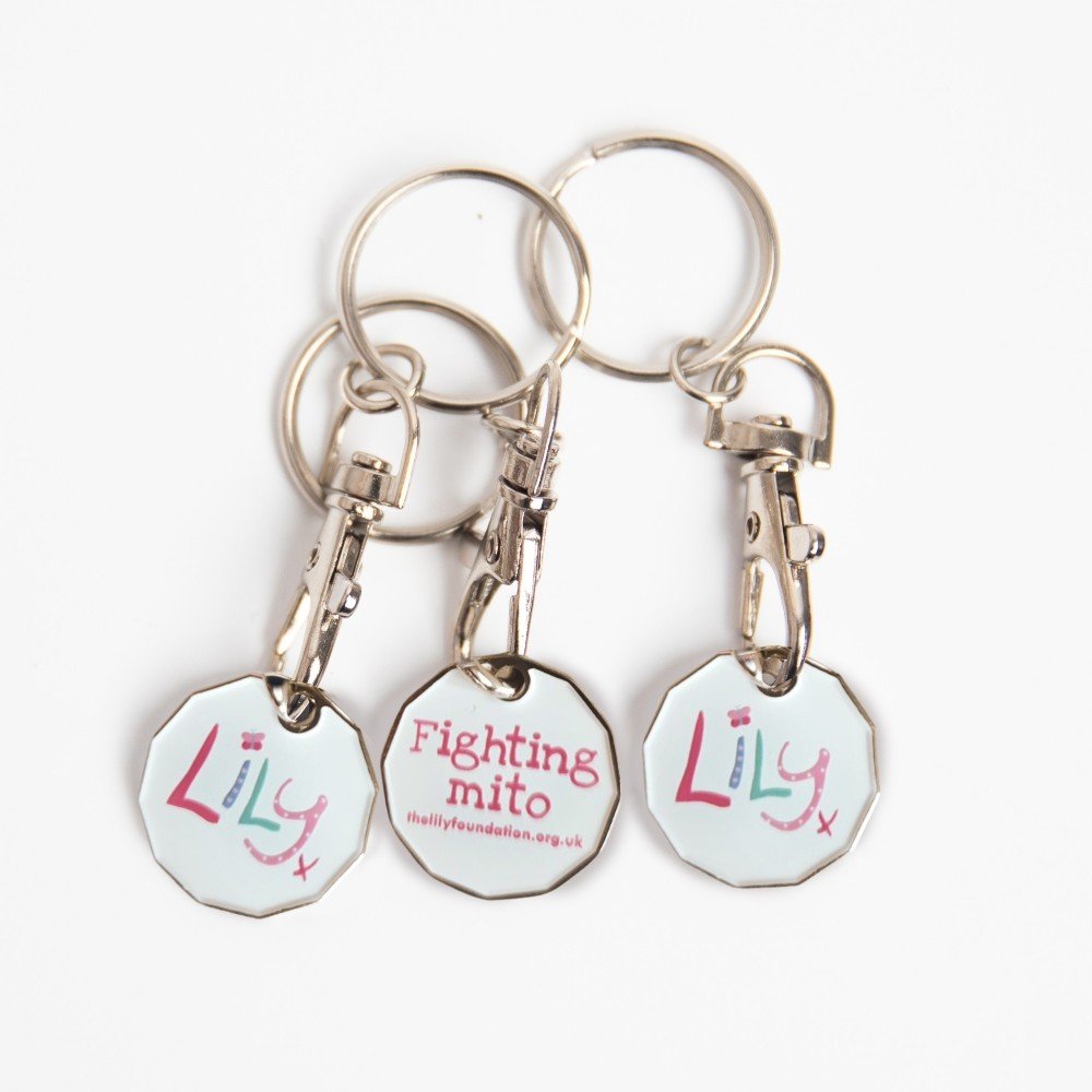 A metal trolley token on a key ring featuring the Lily Foundation logo.