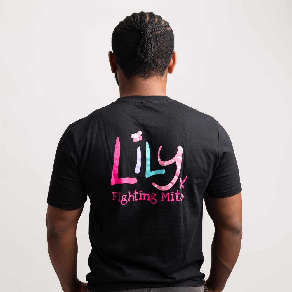 The back of a man wearing a black t-shirt featuring the Lily Foundation logo and the text Fighting mito underneath.