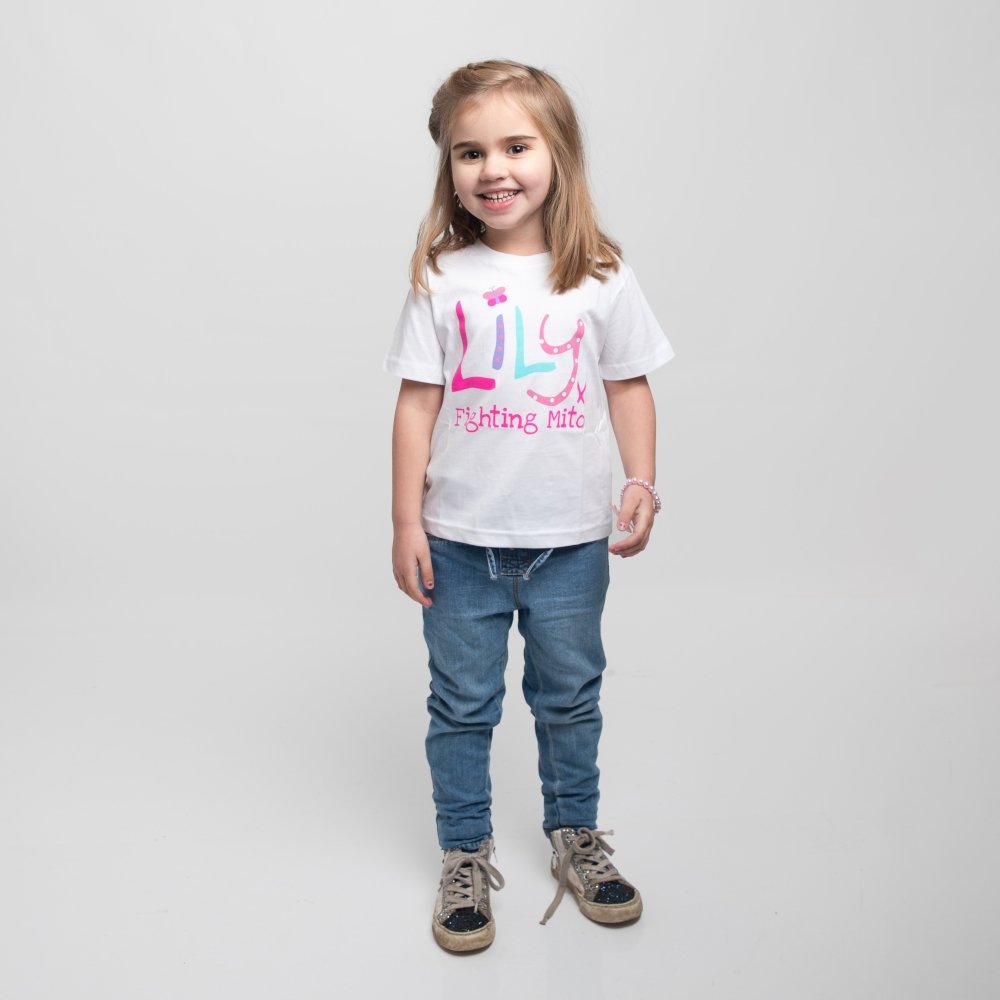 A young girl wearing blue jeans and a white t-shirt featuring the Lily Foundation logo and the website address.