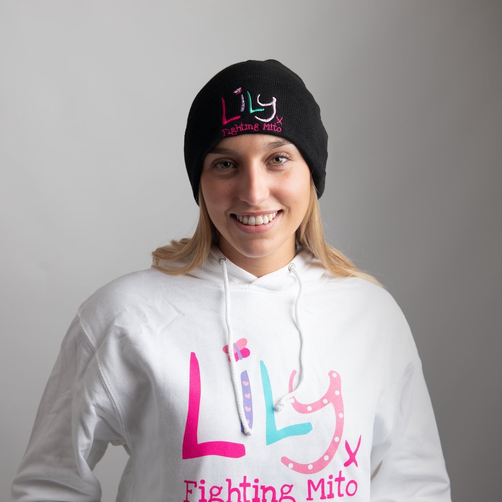 A woman in a black beanie hat featuring The Lily Foundation logo and the words fighting mito.