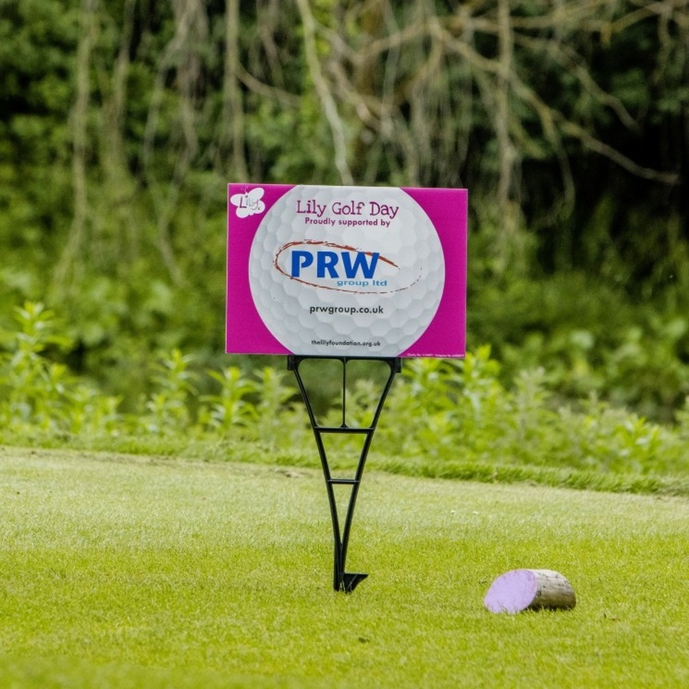 A Lily-branded sponsorship board at a hole on a golf course