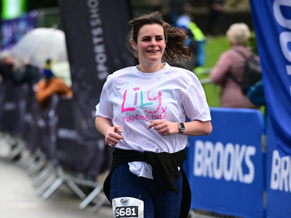 Run Alton Towers Half Marathon 2025 - A lady in a Lily Foundation top running the Alton Towers Half Marathon