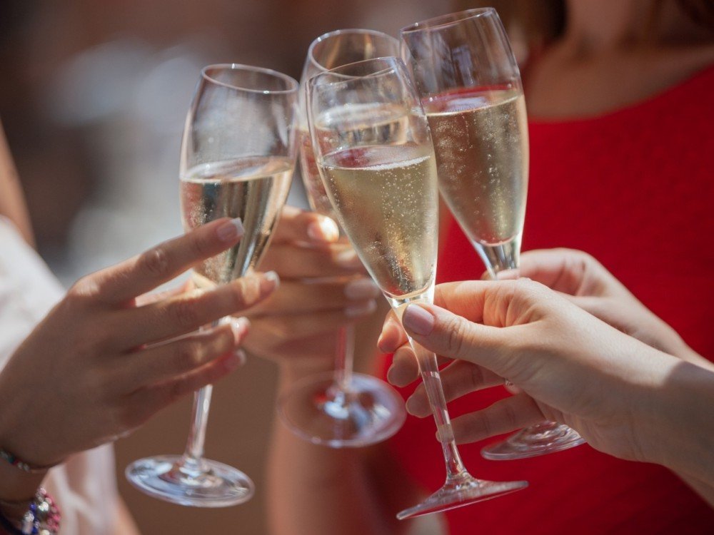 Hands holding up glasses of champagne and clinking