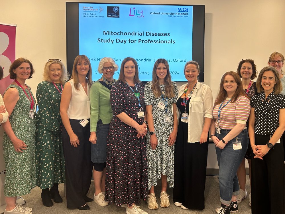 A group of people standing in front of a large screen at a mito study day