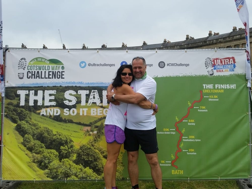 A man and woman in Lily Foundation tops embrace at the finish of the Cotswolds Way Ultra Challenge