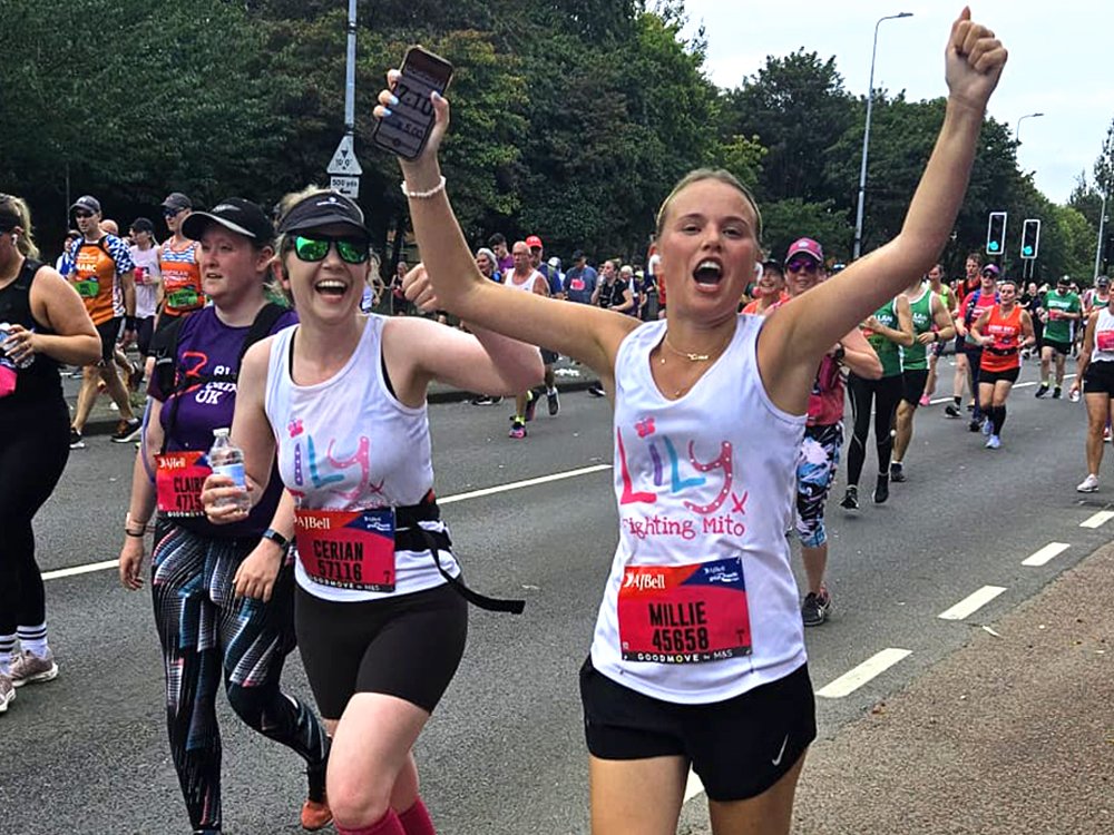 2 female runners cheering as they are running in the Great North Run