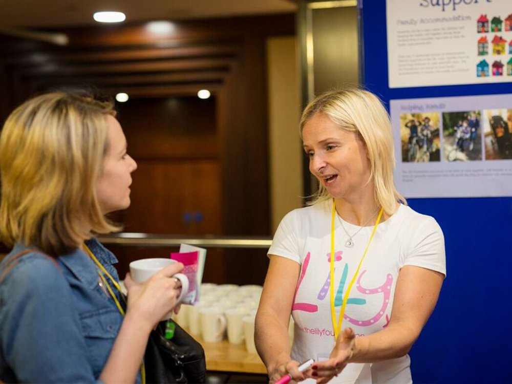 Lily member of staff talking to a lady about the services The Lily Foundation offers