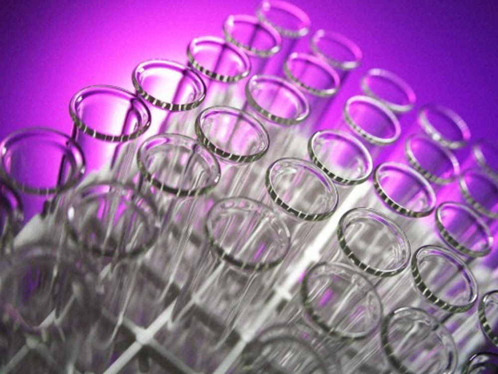 Close-up of a group of empty test tubes against a purple background