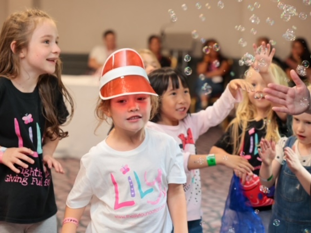 Group of children in Lily t-shirts having fun playing with bubbles