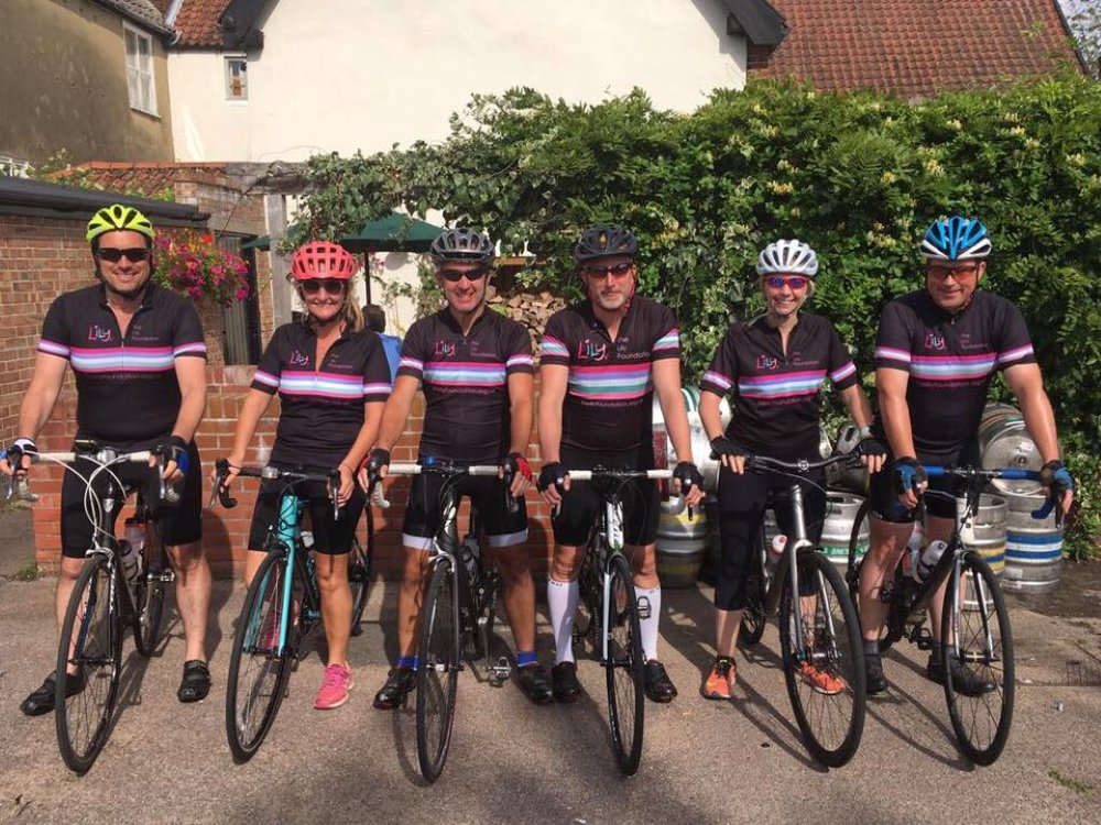A group of people in Lily tops standing with their bikes ready to cycle a challenge
