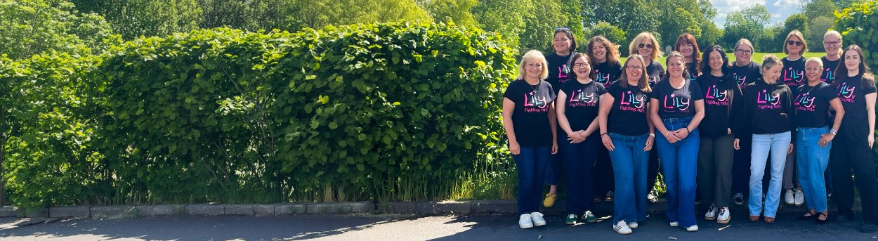 The Lily Foundation team standing together in a row outdoors wearing Lily tops