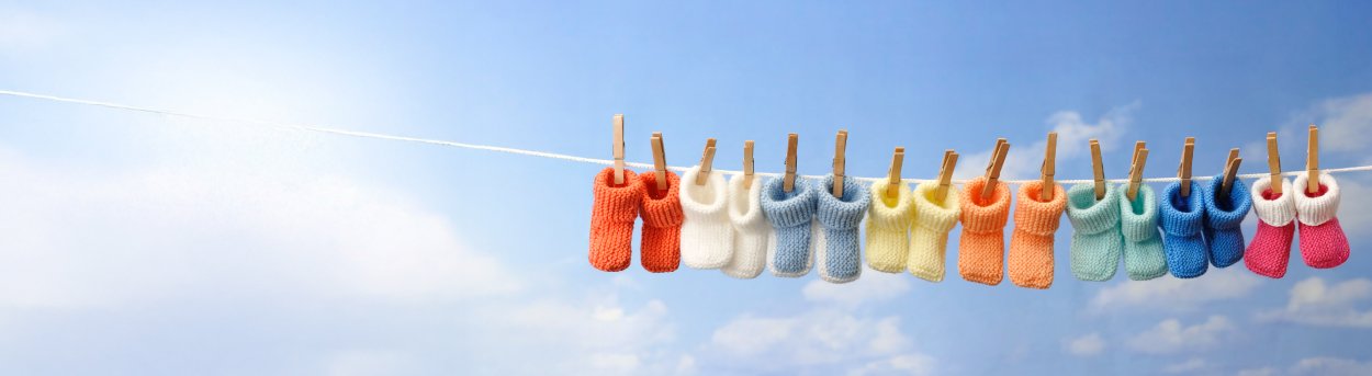 Eight baby bootees hanging on a washing line