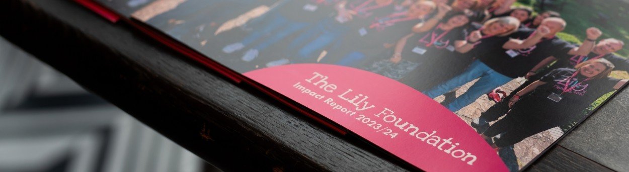 A pile of Lily Foundation impact reports laid out on a desk