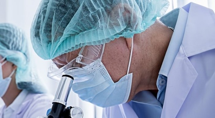 Two scientists wearing protective clothing working on research in a lab