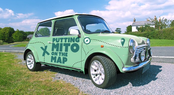 Green Mini Cooper with 'Putting mito on the map' logo on the side
