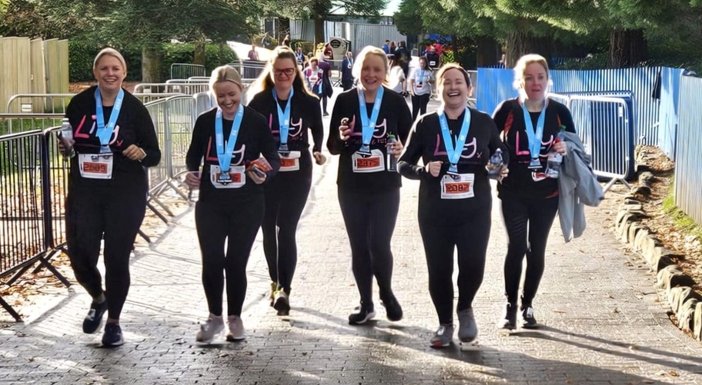 A group of fundraisers wearing Lily Foundation tops and running together