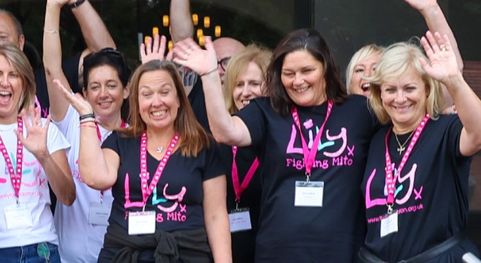 A group fo people in Lily Foundation tops standing and waving