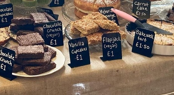 A table laid out with lots of different cakes and treats for a charity bake sale