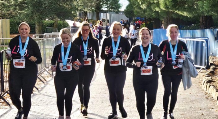 A group of ladies wearing Lily Foundation hoodies and walking together laughing
