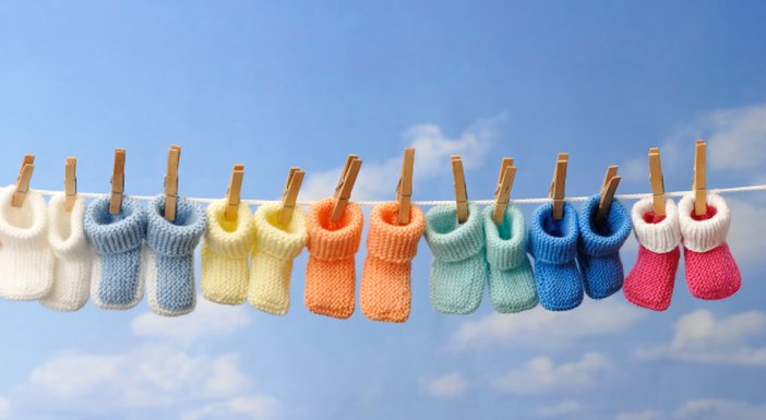 Eight baby bootees hanging on a washing line