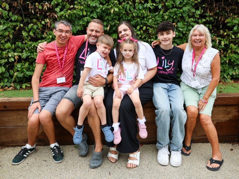 A family group sitting on a wall together at the Lily Family Support Weekend