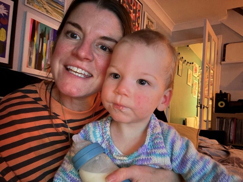 A lady smiling and holding her young mito warrior Felix close