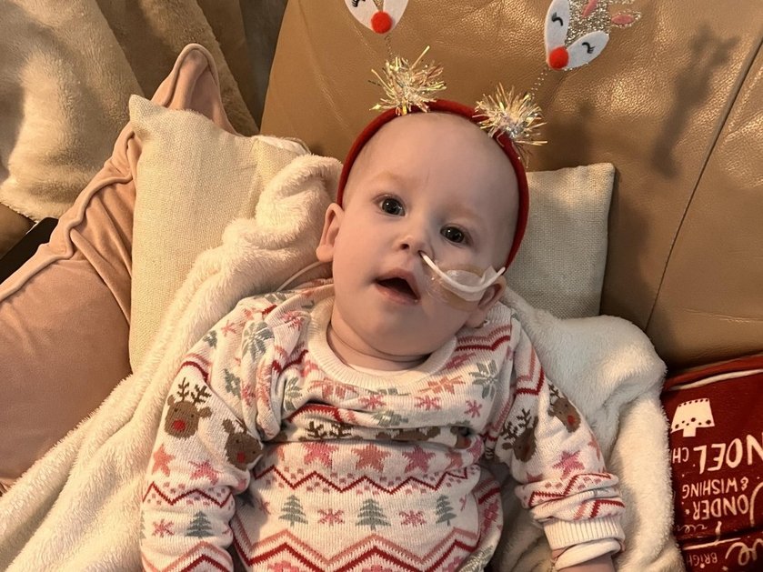 A young mito patient wearing a Christmas jumper and lying on a sofa