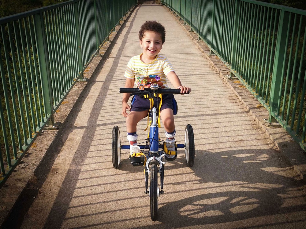 A small boy on a trike cycling towards the camera