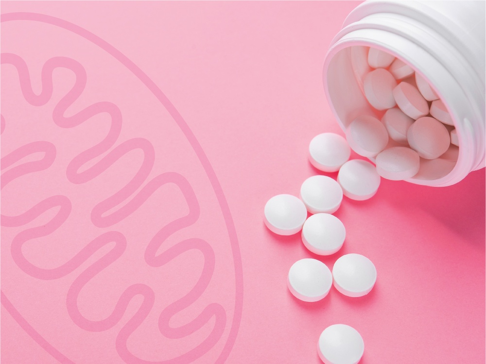 A bottle of white pills on its side with some spilling out onto a pink surface