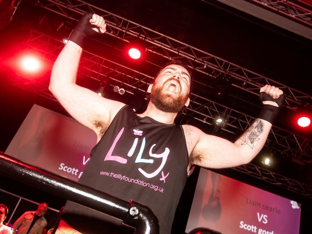 A Lily fight night boxer with his hands in the air